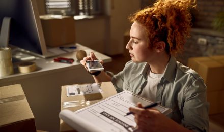 Woman Working Fulfilment Centre Scanning Parcels